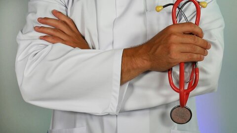 photo of someone in a white coat holding a stethoscope