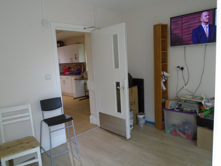 Photo of a room with chairs and a TV mounted on the wall