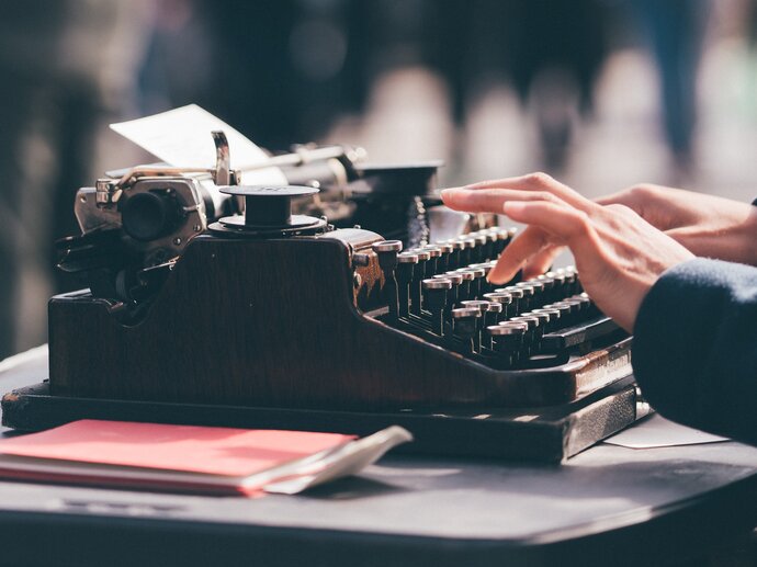 A pair of hands typing on a typewriter