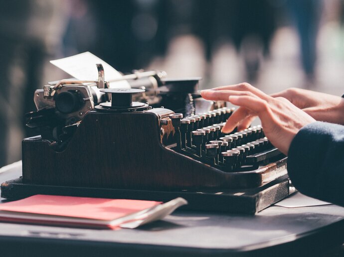 A pair of hands typing on a typewriter