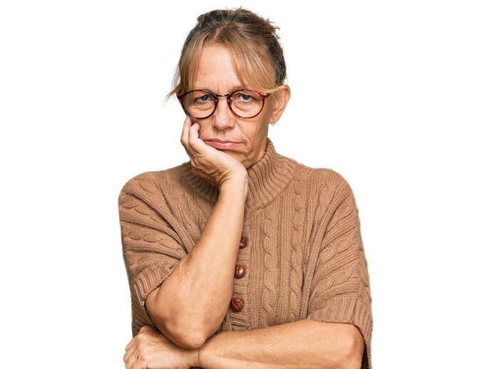 photo of a woman with her head resting in her hand, looking bored