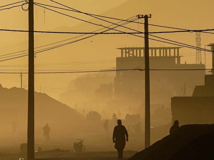 A silhouette of a person against a dusty yellow cityscape background