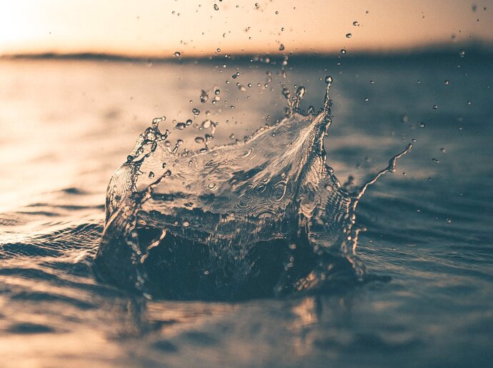 A large splash as if a rock has been thrown into the sea