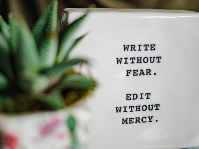 photo of a tablet engraved with the words "Write without fear, edit without mercy"