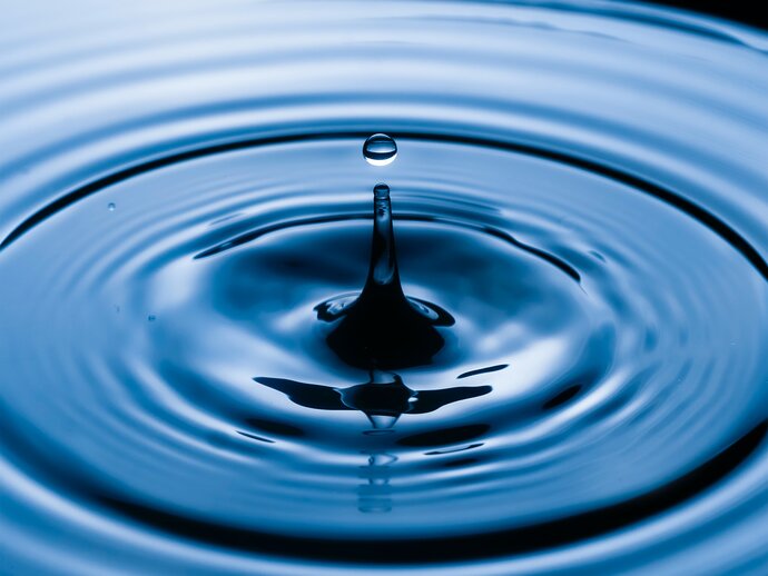 Splash and ripples in clear blue water