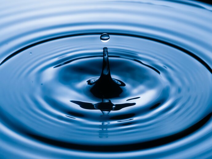 Splash and ripples in clear blue water