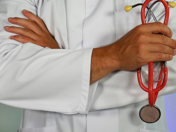 photo of someone in a white coat holding a stethoscope