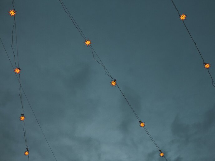 Star shaped fairy lights against a cloudy night sky background