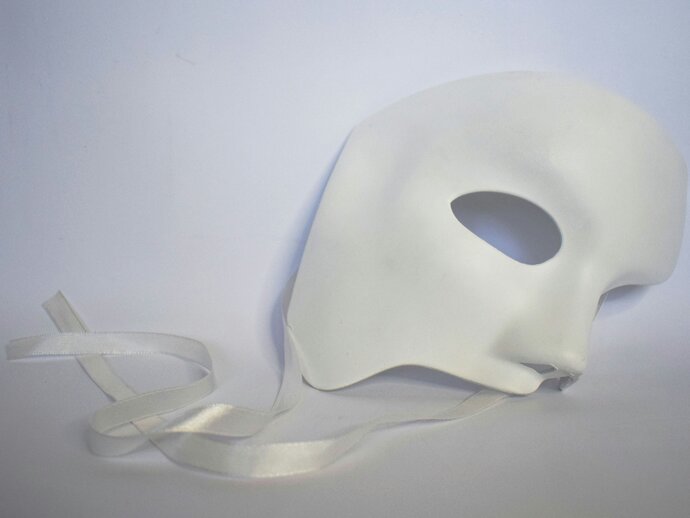 White theatrical mask on a pale background