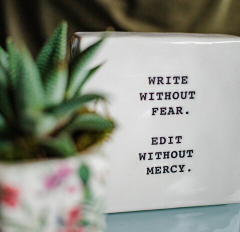 photo of a tablet engraved with the words "Write without fear, edit without mercy"