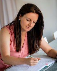 Gemma McKenzie, sitting at a desk writing