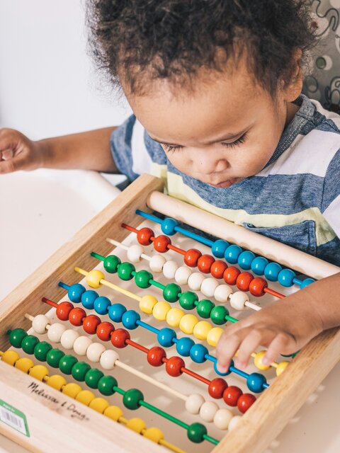 Small child playing with an abacus