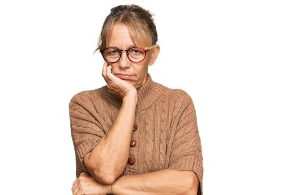Photo of a woman with her head resting in her hand, looking bored