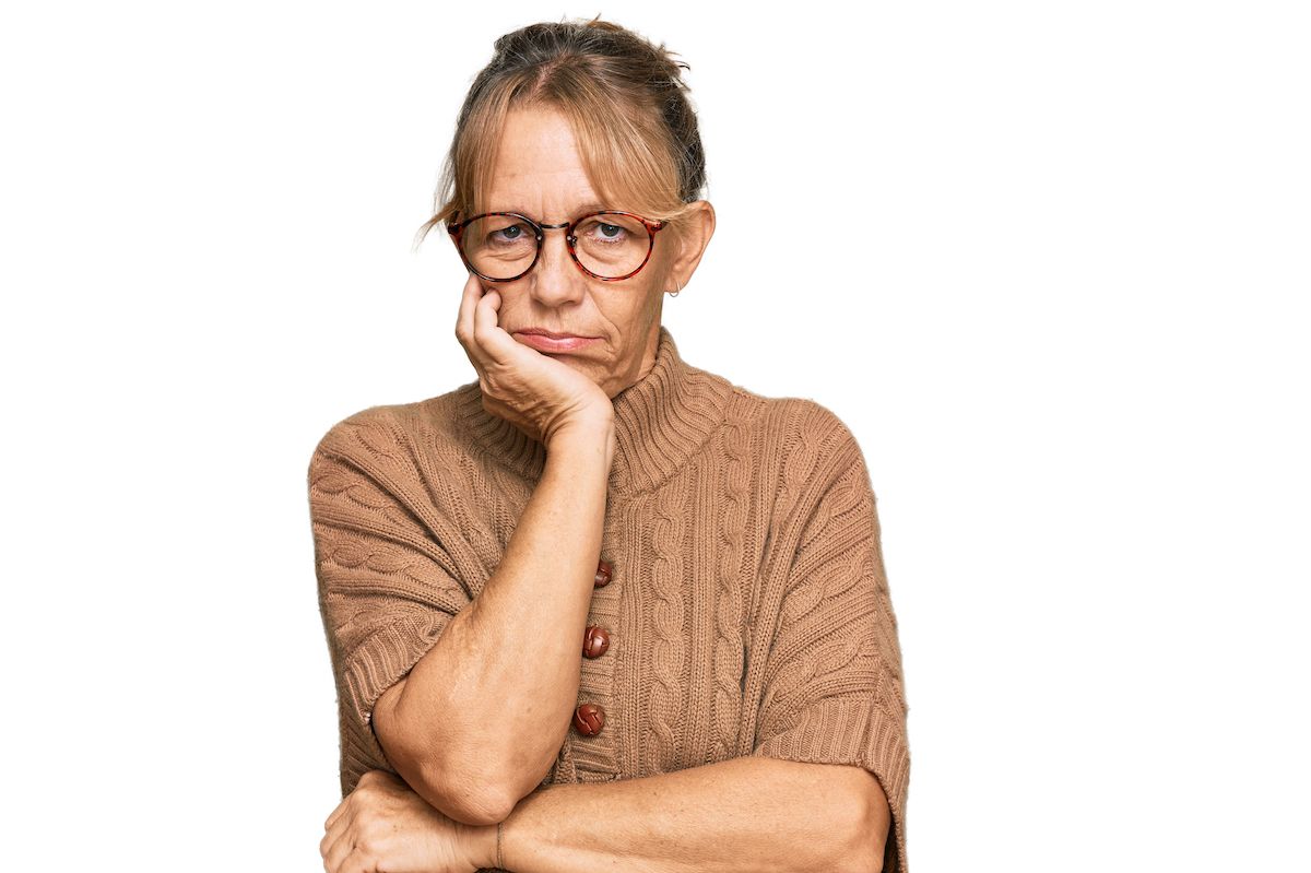 Photo of a woman with her head resting in her hand, looking bored