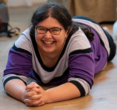Alyssa Zisk lying down on the floor, smiling