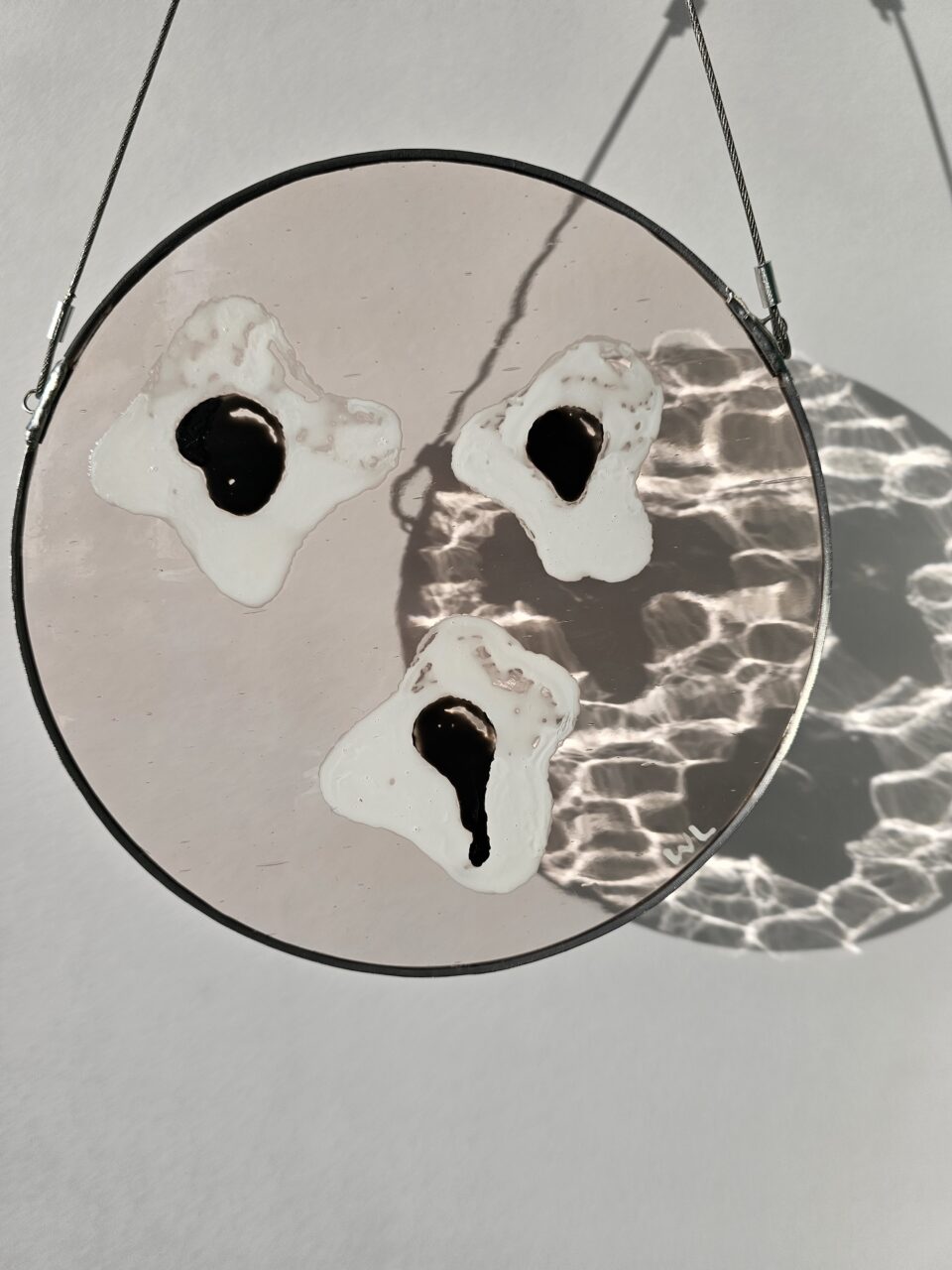 Glass painting casting dramatic shadows on the wall behind