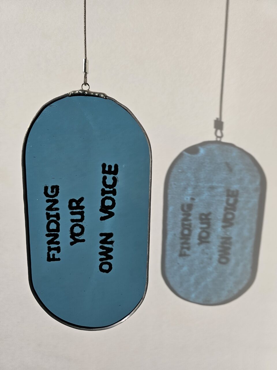 Painted glass with the text "finding your own voice"