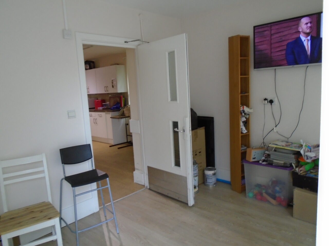 Photo of a room with chairs and a TV mounted on the wall