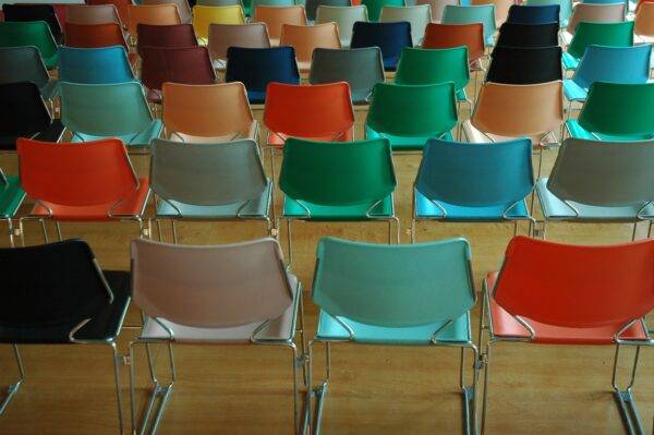 Several rows of colourful plastic chairs, viewed from behind