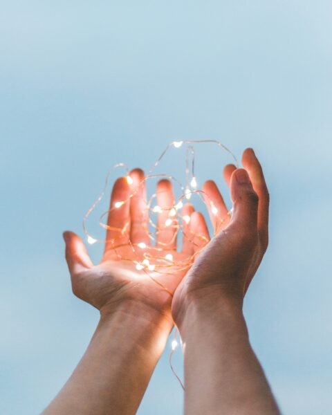 Photo of hands holding a set of string lights